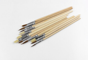 set of paint brushes in a row on white isolated background, copy space, top view