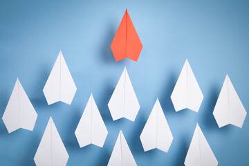 Red and white paper airplanes on blue background. Leadership. Teamwork