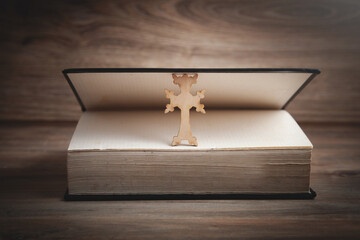 Christian cross and Bible on the wooden background.