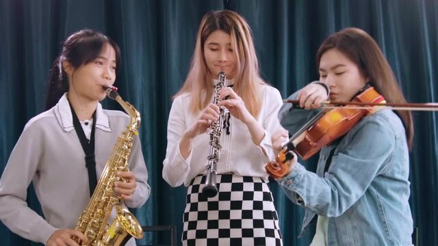 Beautiful Female musician playing instrumental oboe saxophone violin flute guitar use laptop computer singing online streaming broadcast teaching tutorial webcam live show
