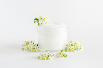 Fototapeta na wymiar White blossoms flowers with skin cream in glass jar