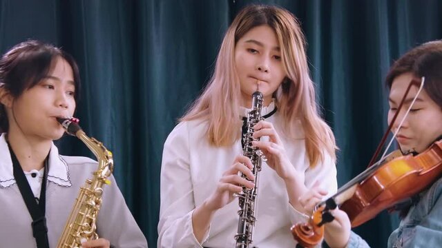 Beautiful Female musician playing instrumental oboe saxophone violin flute guitar use laptop computer singing online streaming broadcast teaching tutorial webcam live show
