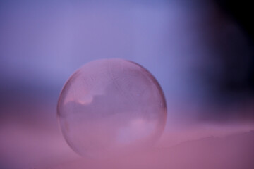 frozen soap bubble at a very cold morning in a cold blue pink light
