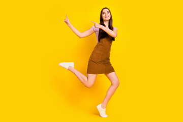 Fototapeta na wymiar Full length body size view of attractive cheerful girl showing copy space dancing isolated over bright yellow color background