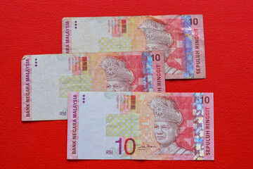 Background of Malaysian ringgit banknotes. Malaysian ten ringgit banknote. on red background