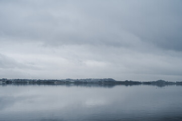Obraz premium Scenic landscape of foggy fjord at cloudy day. Nature of Norway. Hafrsfjord, Stavanger.