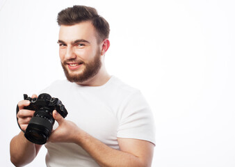 A young bearded male photographer is looking at the photos he has taken on his camera isolated on white background.