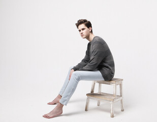 Stylish fashion man model sitting on the chair.