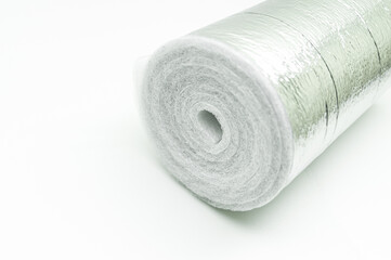 A roll of insulation made of foamed polyethylene with aluminum foil. Thermal insulation with reflective foil. Selective focus, copy space