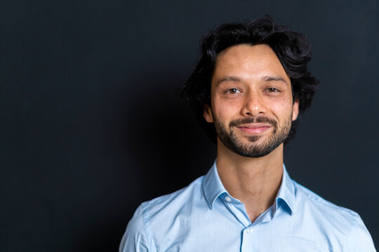 Male entrepreneur smiling against black background