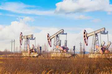 Fototapeta na wymiar Three oil pumping pumps extract oil from an oil field in Russia