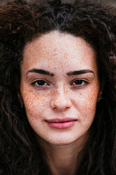 Beautiful young curly haired woman with freckles