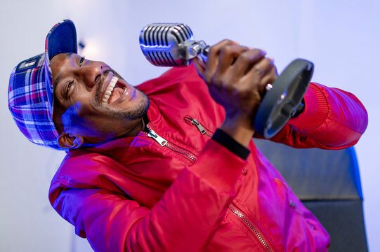 Cheerful male influencer enjoying during podcast in studio