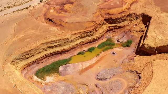 Aerial Beautiful Shot Of Water Pond Amidst Landscape During Sunny Day - Mitzpe Ramon, Israel