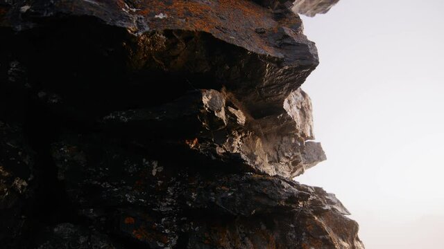 Camera moving around rockformation close up with orange moss
