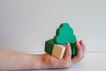 WOODEN TOY BLOCKS WITH CHILDREN HAND ENVIRONMENTAL GREEN EDUCATION CONCEPT