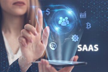 Business, Technology, Internet and network concept. Young businessman working on a virtual screen of the future and sees the inscription: SAAS