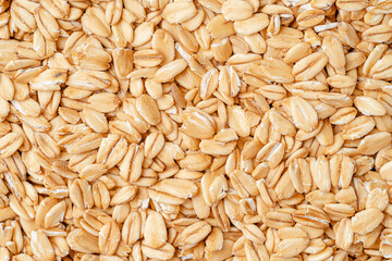 Rolled oat, oat flakes background or texture. Close up, directly above.