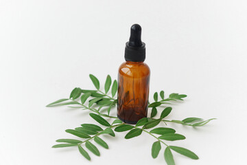 Cosmetic oil on a background of green leaves