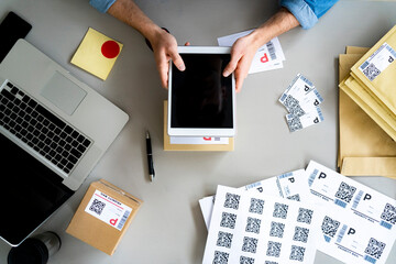 Businessman holding digital tablet over box at desk