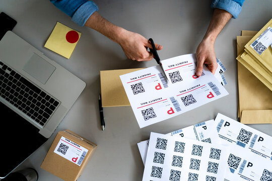 Male entrepreneur cutting QR code label at desk