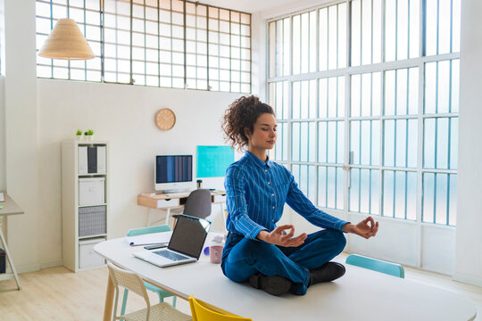 Female entrepreneur meditating while sitting in office