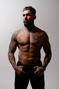 Muscular shirtless tattooed guy in studio