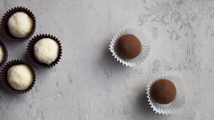 Coconut candy and chocolate truffles on a gray backgound. Delicious homemade dessert made from natural ingredients.