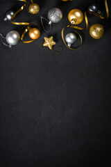 Black christmas background with golden decorations. Flat lay image with space for design.