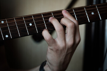 Hand playing on a guitar.