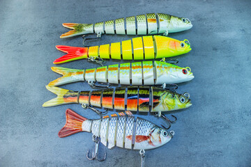 Colorful silicone fishing baits with plummets on wooden table. Various fish and worms and crayfish....
