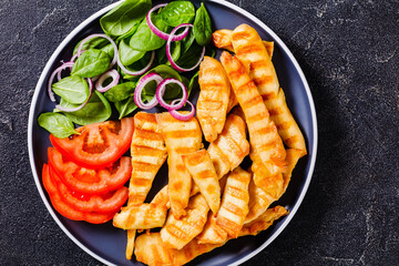 grilled chicken strips on a plate with vegetables