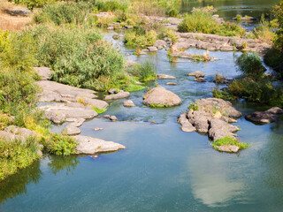 View of a calm river with rocky banks and rapids.