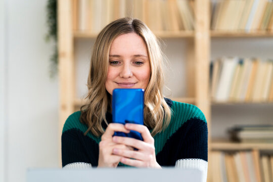 Smiling Woman Taking Selfie Through Mobile Phone At Home