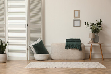 Stylish room with folding screen and furniture. Interior design