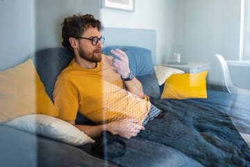 Man talking on mobile phone while sitting on sofa at home