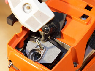 Chainsaw carburettor intake hole and air filter closeup under cap without cover - test, maintenance and service of power tool equipment before a work