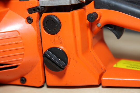 Orange chain saw fuel filling cap closeup - forestry tool equipment refueling maintenance - Powered by Adobe