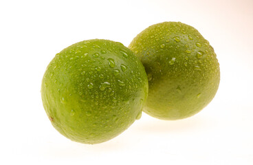 Lemons being one cut in half on white background.