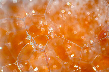 Abstract orange texture of soap bubbles close up.