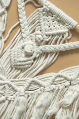 Macrame. Handmade macrame weaving and cotton threads on a rustic wooden stick. Scandinavian style in the interior, boho style. Cozy home.recycling, zero waste,eco friendly,  small business