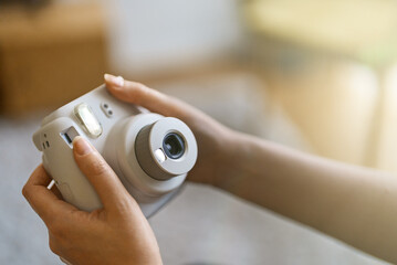 Woman doing selfie photo with instant camera.