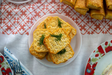 There are biscuits in the plate on the table. Against the background of a white tablecloth.