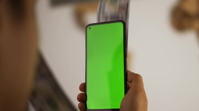 Cash is flying out of the phone with green screen