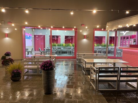 Pink And White Cafe Exterior With Cozy Lights At Night