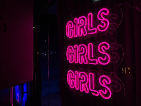Girls neon sign glowing pink at night
