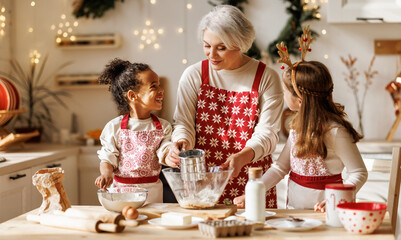 Multiethnic family, grandmother and two little kids, cooking Christmas cookies together in kitchen