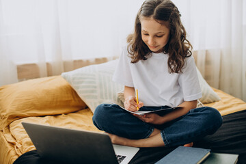 School girl studying at home, distant learning