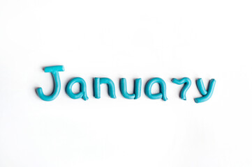 The word January is made of blue plasticine on a white background