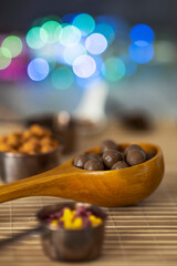 Still life with chocolates, nuts and decorative colored lights